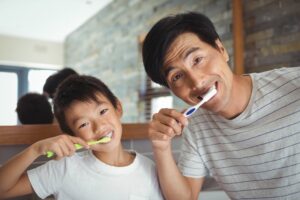 A son and father brushing their teeth